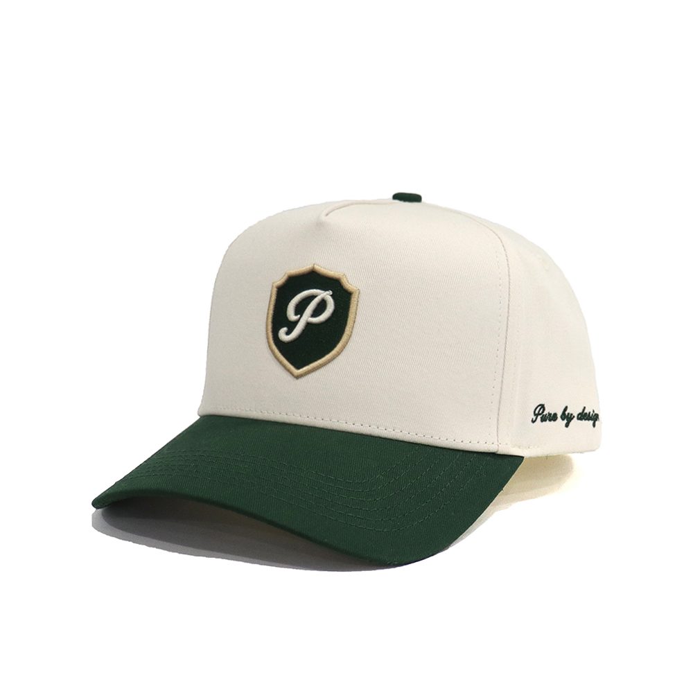 The Club Cap shown at an angle, with 'Pure by design' embroidered on the side
